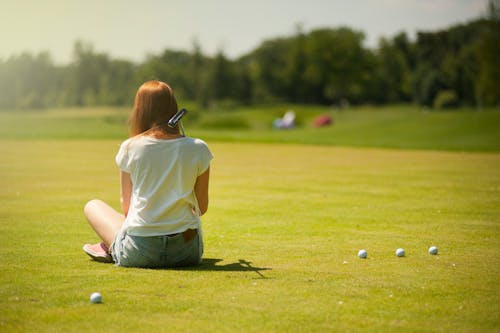 Фотография женщины, сидящей на траве
