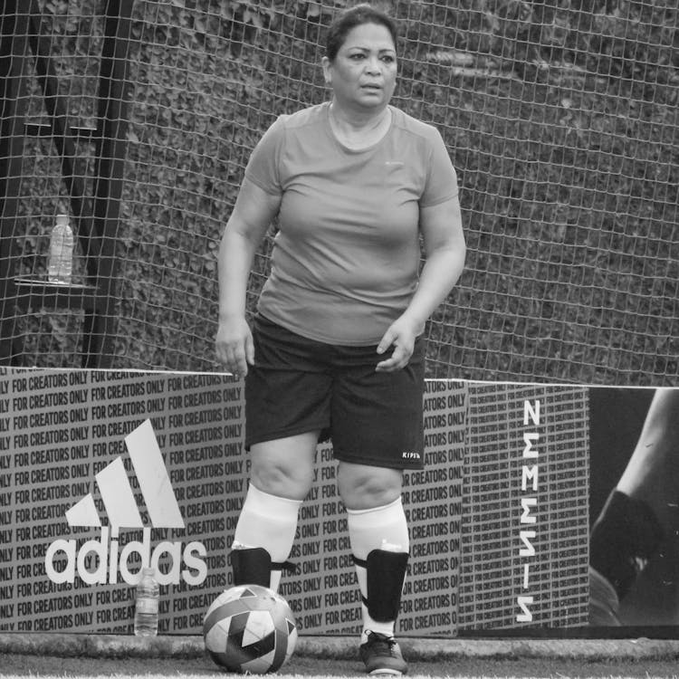 Grayscale Photo Of A Woman Playing Football