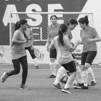Women playing soccer on an outdoor field, capturing teamwork and sports activity.