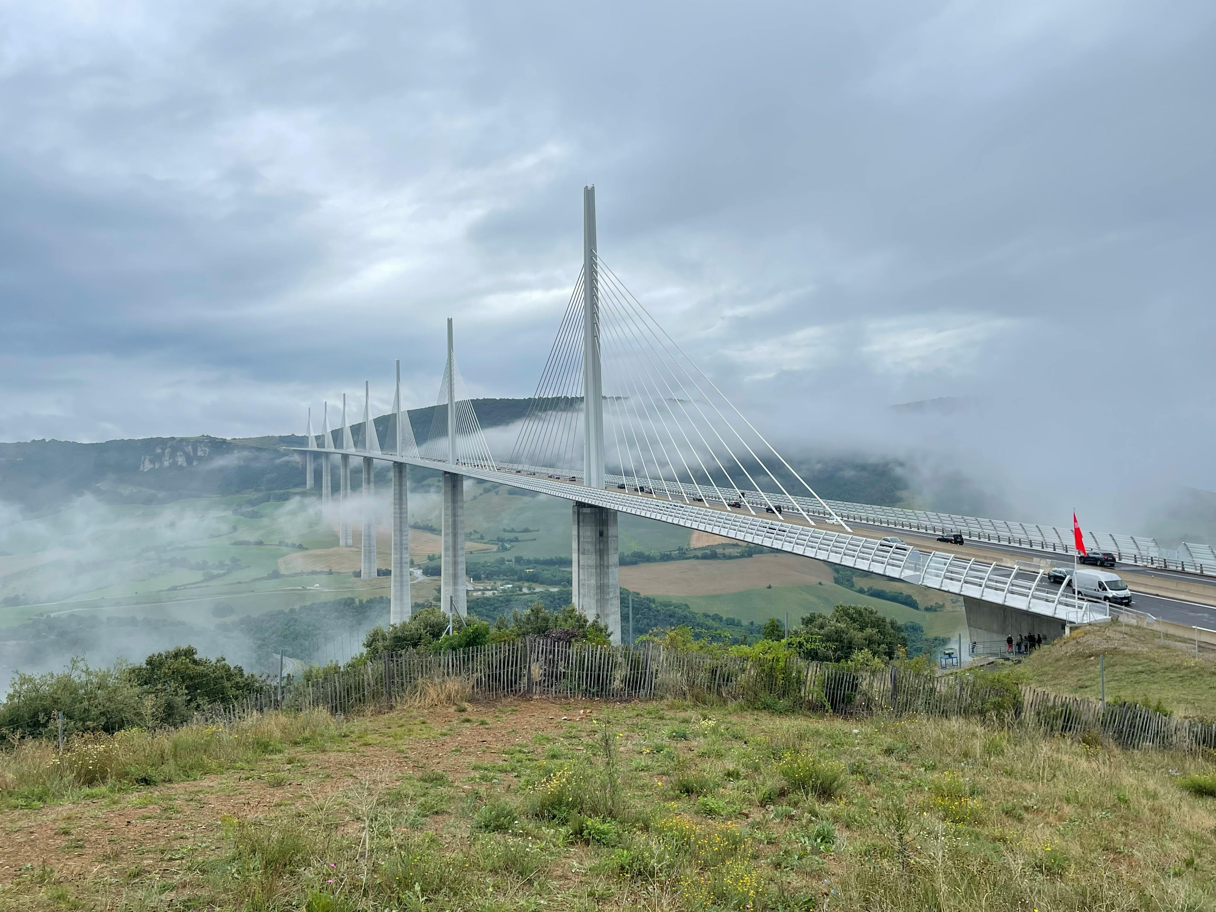 Millau Viaduct soaring above Tarn River valley with slender pylons and cable-stayed deck at sunrise