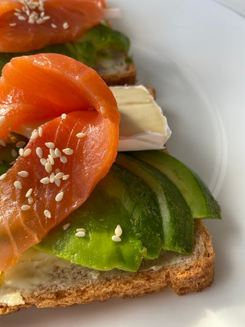 Free Delicious gourmet toast topped with smoked salmon, avocado, and creamy cheese. Stock Photo