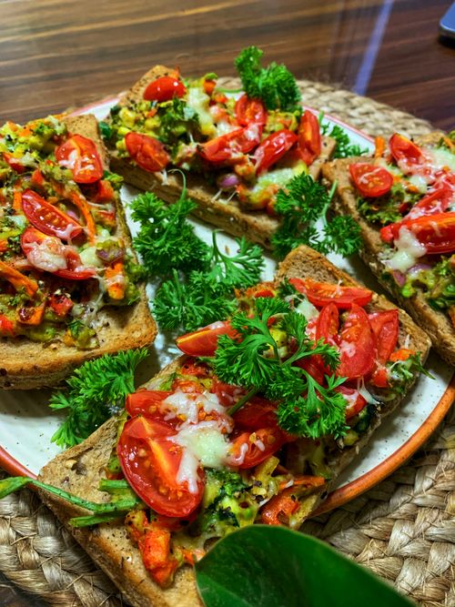 Free Nutritious open-faced sandwiches with cherry tomatoes and greens. Stock Photo