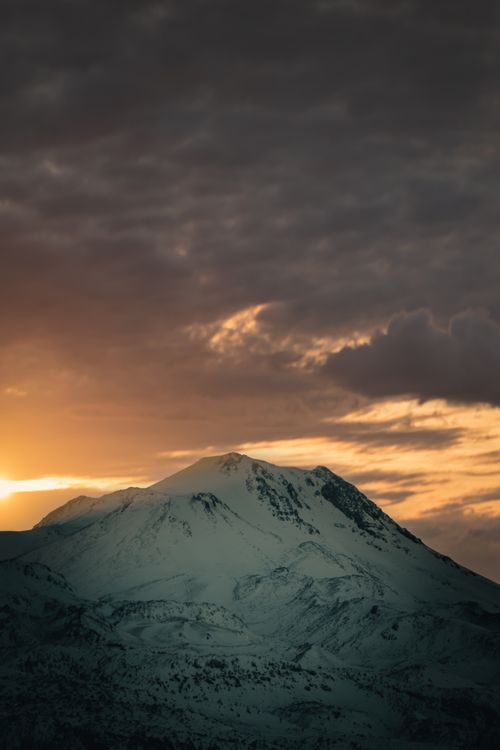 Free Snow-covered mountain at sunset with dramatic skies in Aksaray, Turkey. Stock Photo