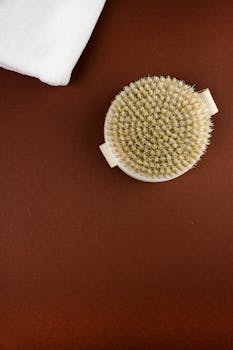 Top view of a natural bristle body brush on a brown background with copy space.