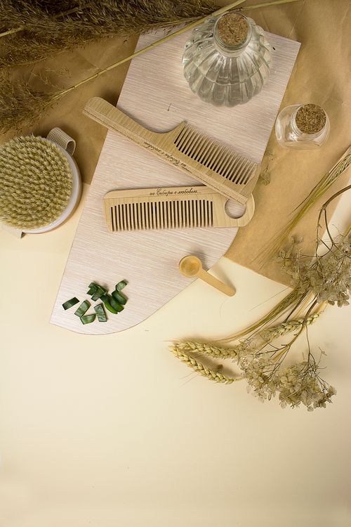Free Stylish flat lay featuring wooden combs on a board, surrounded by pampas grass and glass bottles. Stock Photo