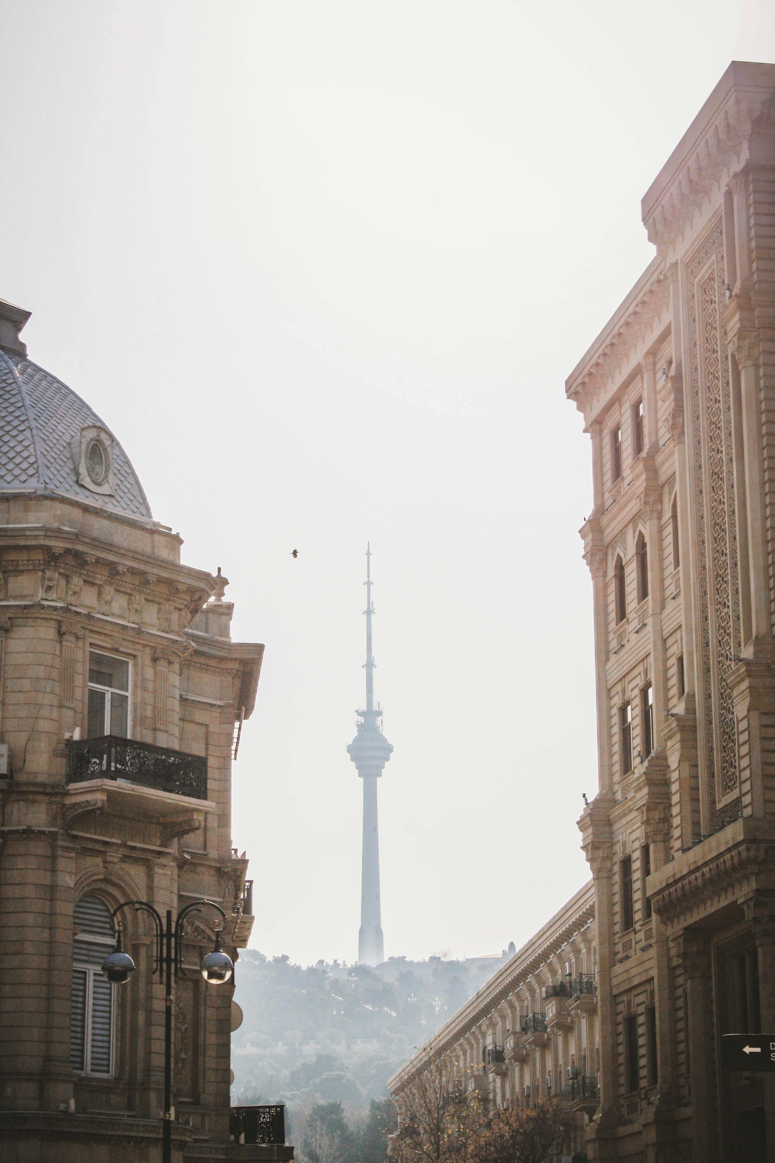 A classic view of Baku's TV Tower framed by historical architecture and clear skies.