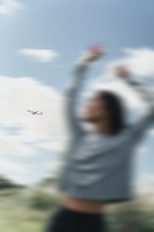 Free An Airplane in the Sky behind a Woman Stock Photo