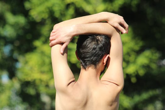Man performs back stretching exercise on a sunny day, promoting wellness and fitness.