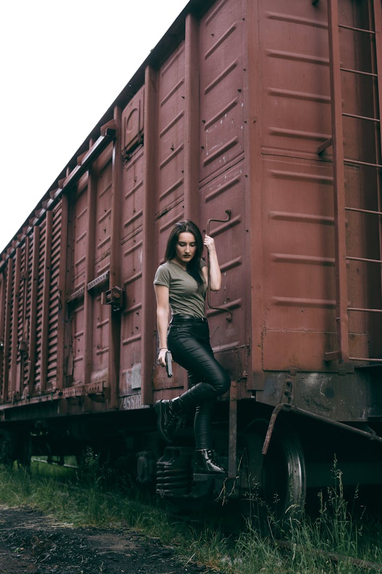 Woman Holding A Gun While Hanging On Train