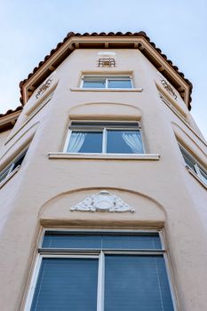 Architectural shot of a multi-story building with decorative arches and windows from a low angle perspective.