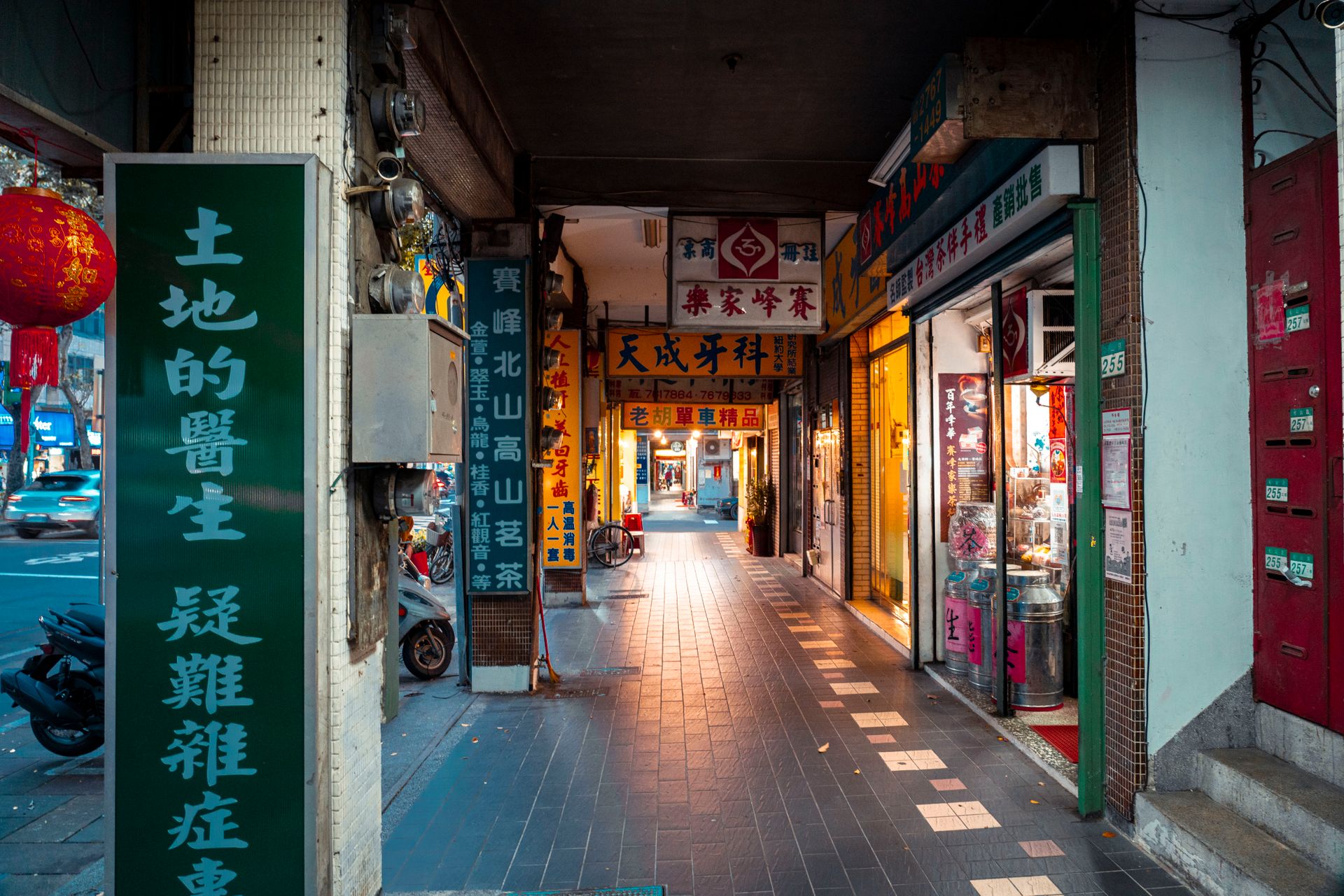 Colorful narrow alleyway with Chinese storefronts and vibrant signage, showcasing urban life.