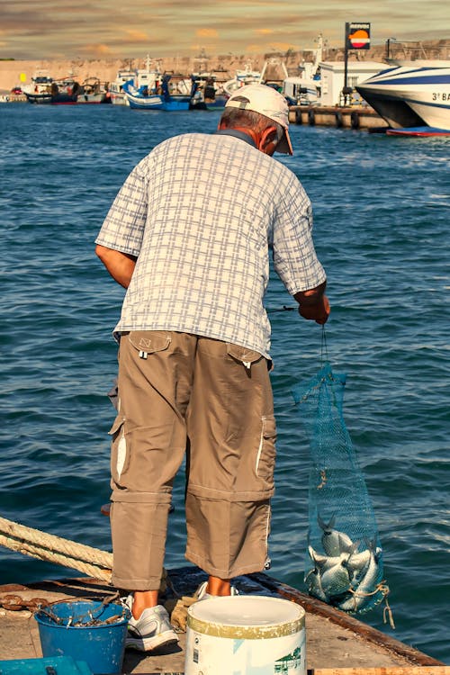 Free Man Catching Fish on the Sea   Stock Photo