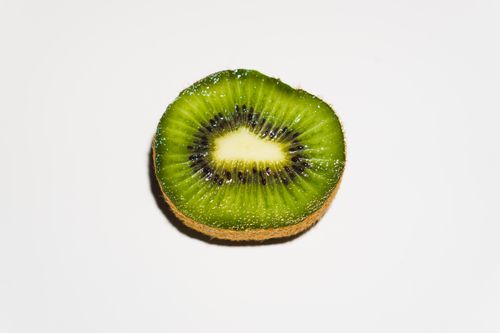 Free Detailed close-up image of a sliced kiwi showcasing its vibrant green color and seeds. Stock Photo