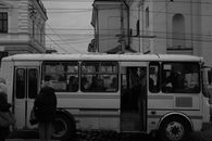 Monochrome photo of a city bus with passengers in Ukraine streets.