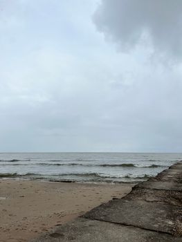 Peaceful beach scene with gentle waves and cloudy sky, perfect for relaxing and unwinding.