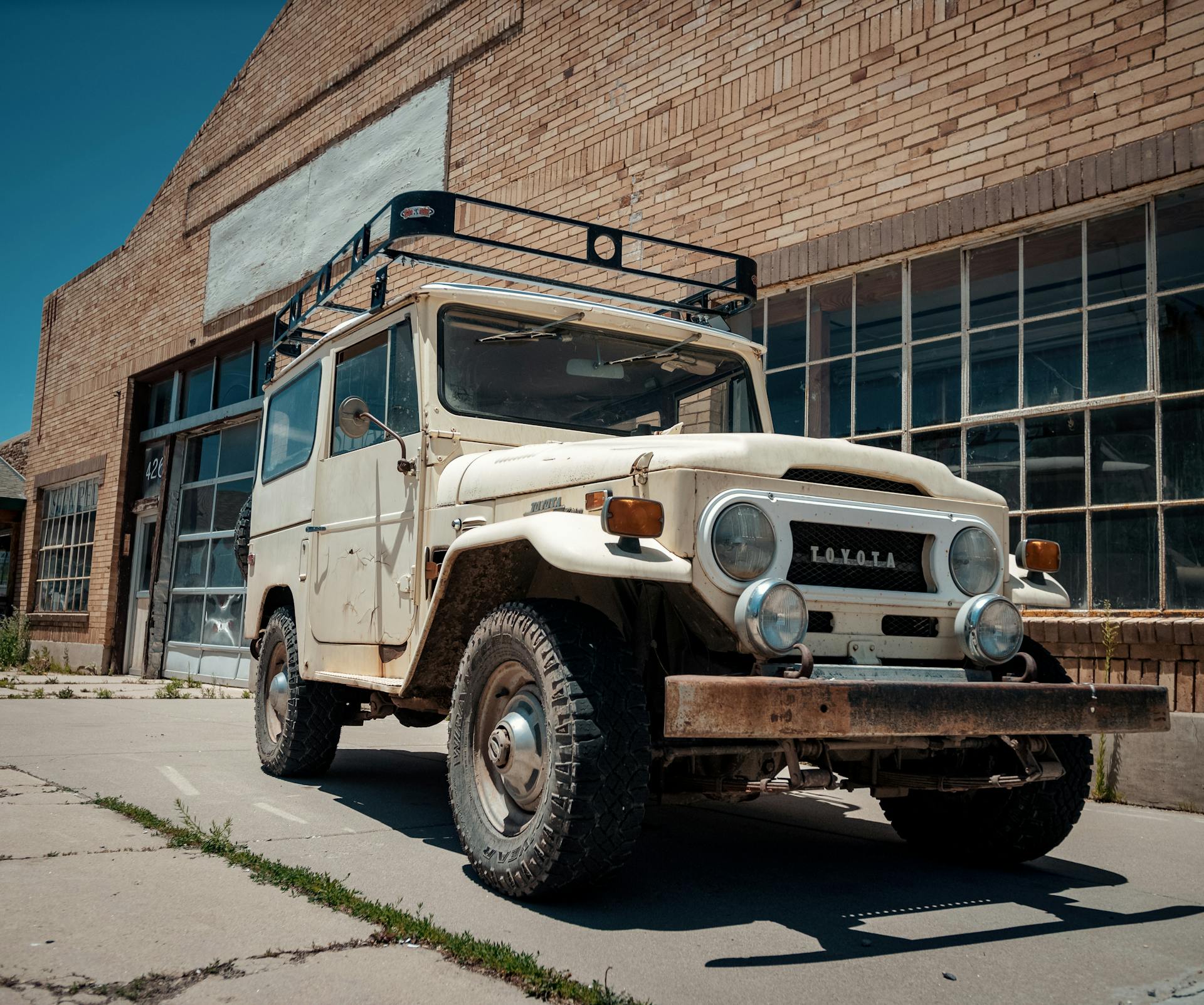 Classic Toyota Land Cruiser parked by a brick building in Arizona, USA.