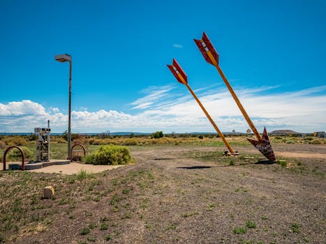 Two iconic giant arrows in the desert near Flagstaff, Arizona under a clear blue sky.