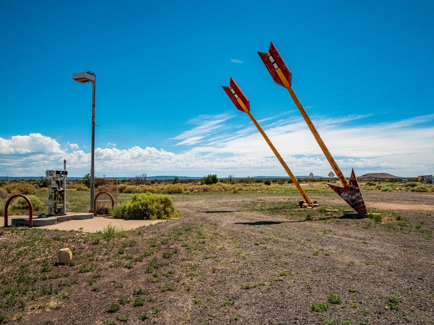 Two iconic giant arrows in the desert near Flagstaff, Arizona under a clear blue sky.