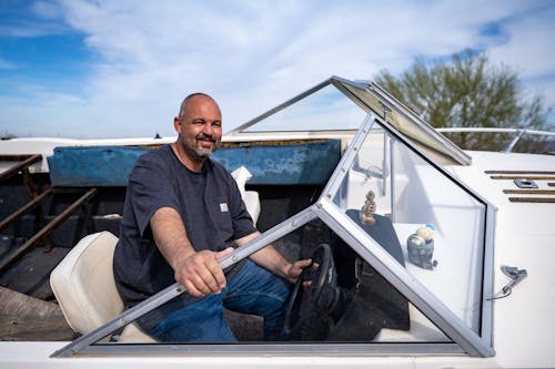 Free A Man Behind the Steering Wheel of a Speed Boat Stock Photo