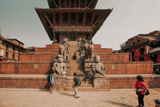 Tourists at the Nyatapola Temple, a landmark of Bhaktapur, Nepal, showcasing its historic architecture.