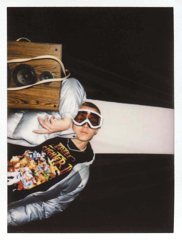 Man In Ski Goggles And Jacket Leaning On A Speaker