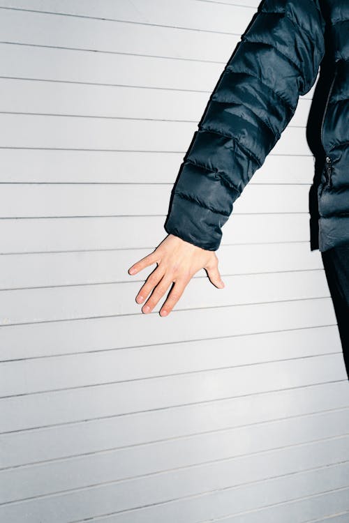 Free Man Standing Against the Wall and Touching It Stock Photo