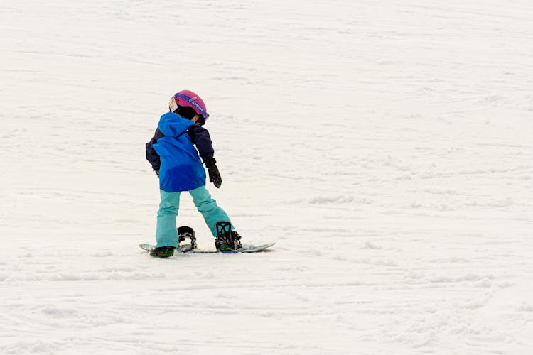 Child Riding A Snowboard