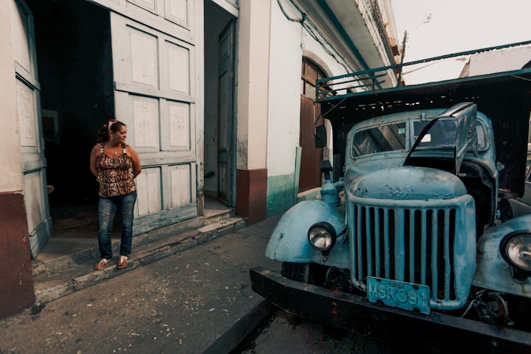 Woman Standing Beside Her House Near A Parked Truck 