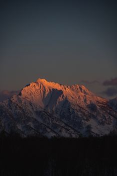 A stunning snow-capped mountain illuminated by sunrise in Kamchatka, Russia.