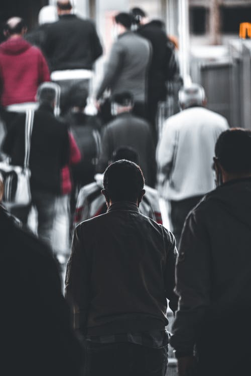 Man in Black Jacket Walking Around People 