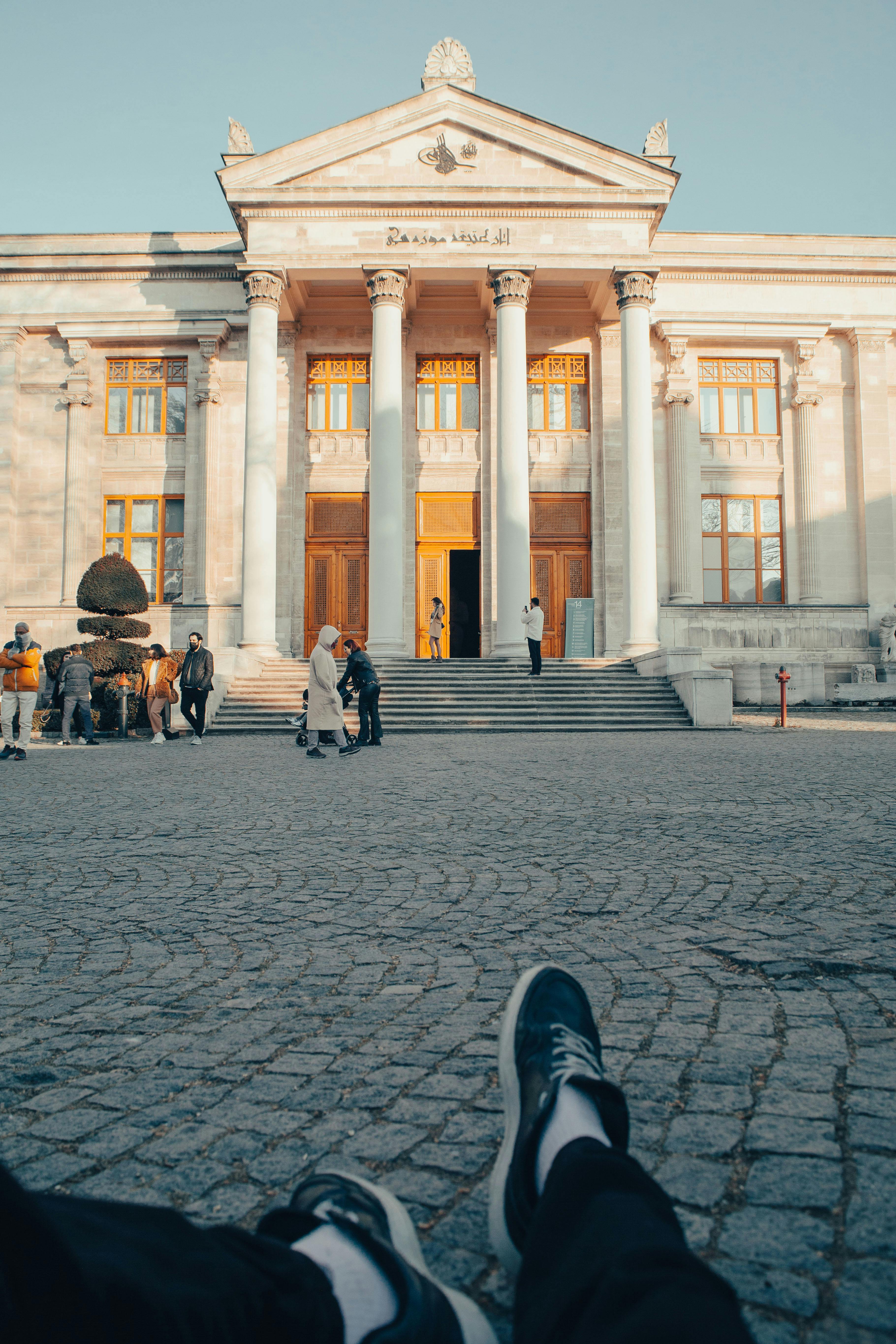 Historic building in Istanbul with visitors and cobblestone path in front.