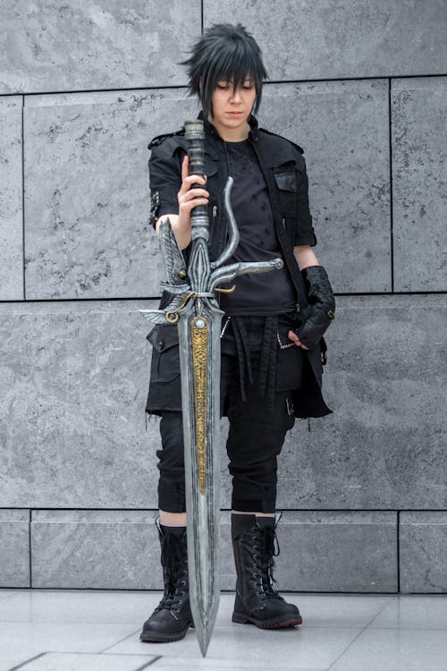 Free A Person Wearing a Costume Posing with a Sword Stock Photo