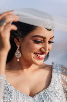 Close-up of a smiling bride in Thiruvananthapuram wearing an embroidered dress and jewelry.