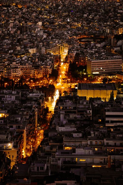Free A dramatic aerial nighttime view of a city's illuminated streets and buildings, showcasing urban life. Stock Photo