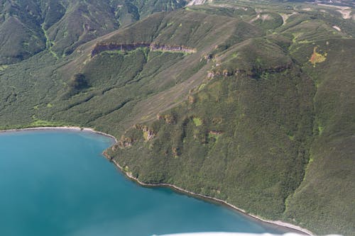 Aerial Footage of Green and Brown Mountains Beside Blue Sea