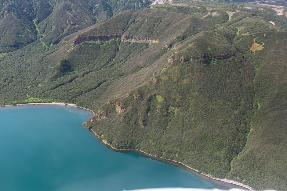 Incredible Siginaka Islands Cruise and Kayak Adventure Review: Your Ultimate Alaska Expedition Experience Review 2026 - A stunning aerial view of a green mountain range beside a serene coastline.