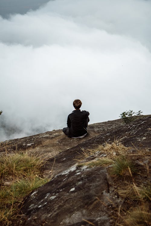 Man in Black Jacket Sitting on a Cliff 