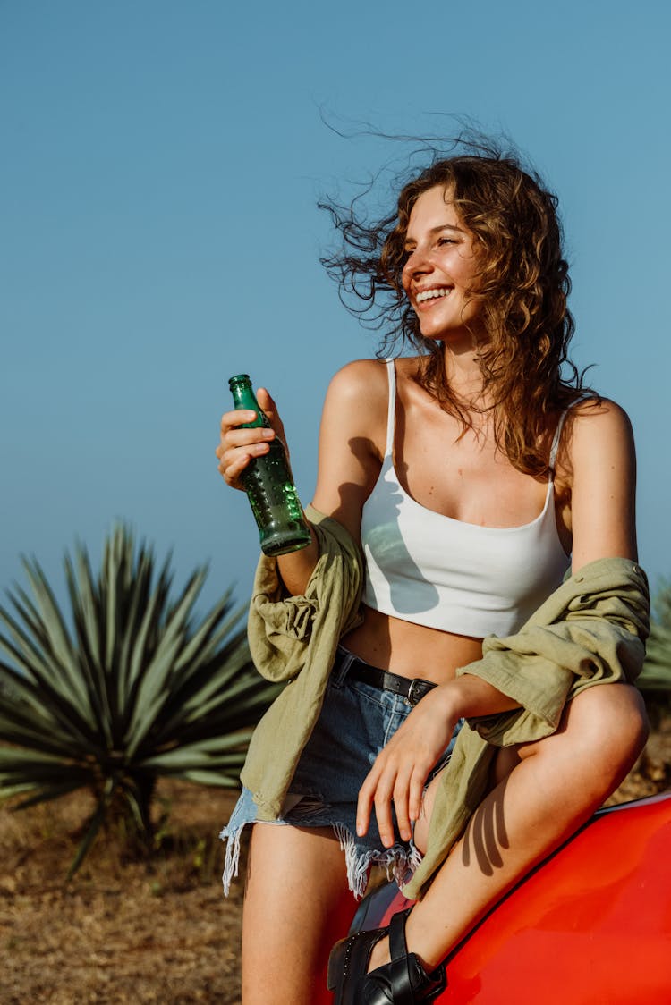 Woman In White Top Holding Green Bottle