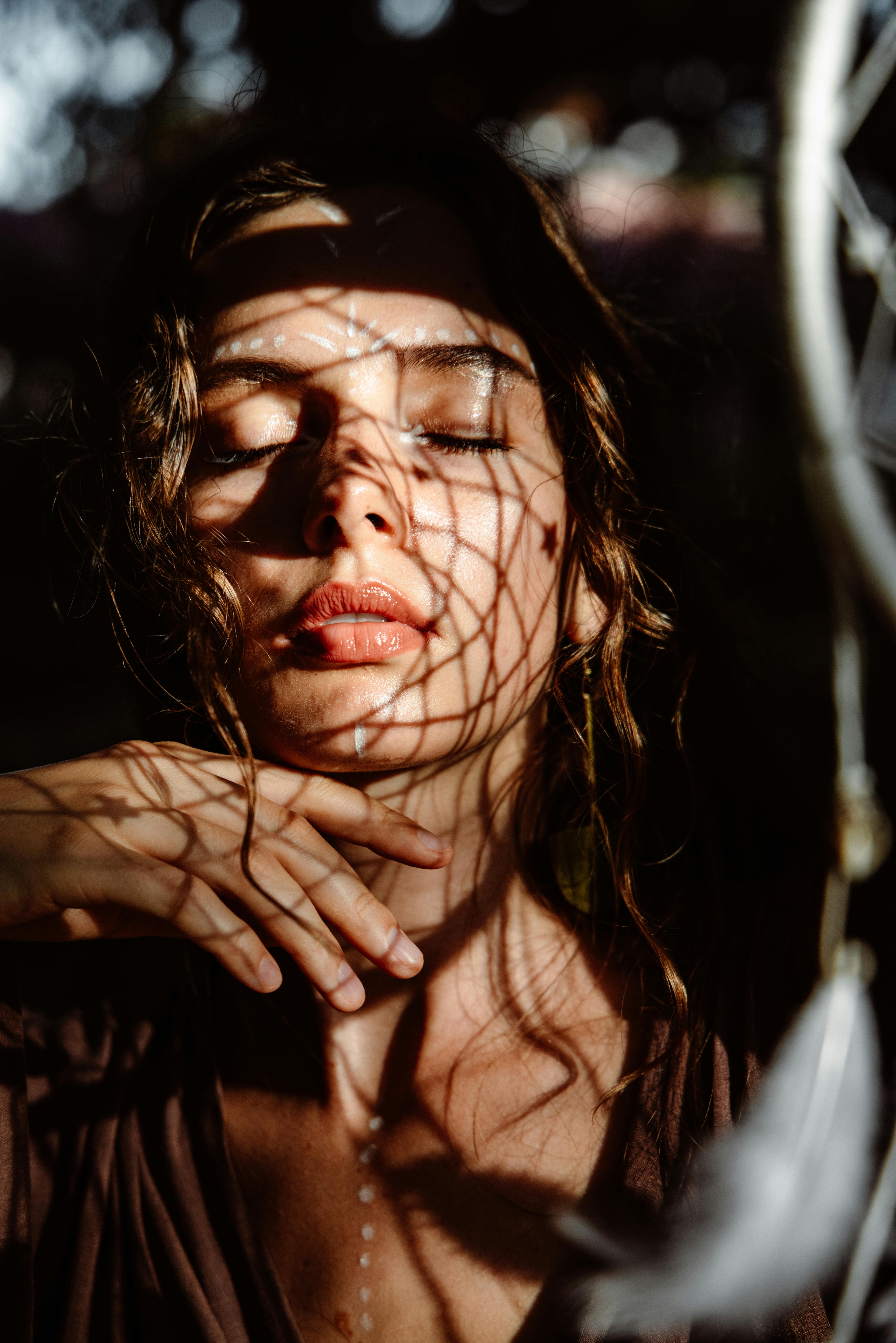 一个迷人的肖像的女人与复杂的阴影在她的脸上，创造一个艺术和神秘的氛围