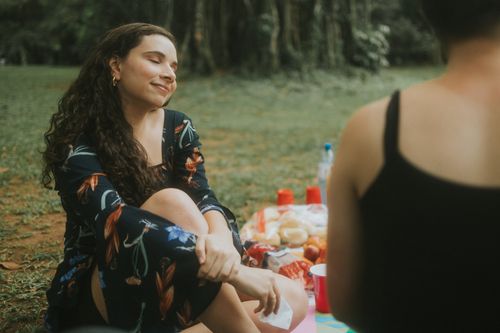 Free Two women enjoying a peaceful summer picnic outdoors, feeling relaxed and happy. Stock Photo