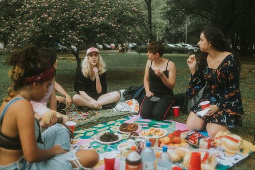 Free A group of women enjoying a picnic at the park with food, drinks, and nature. Stock Photo