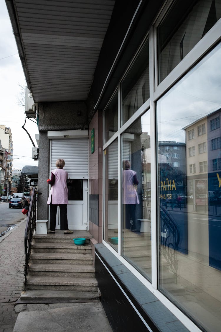  A Woman Cleaning The Store Doorway