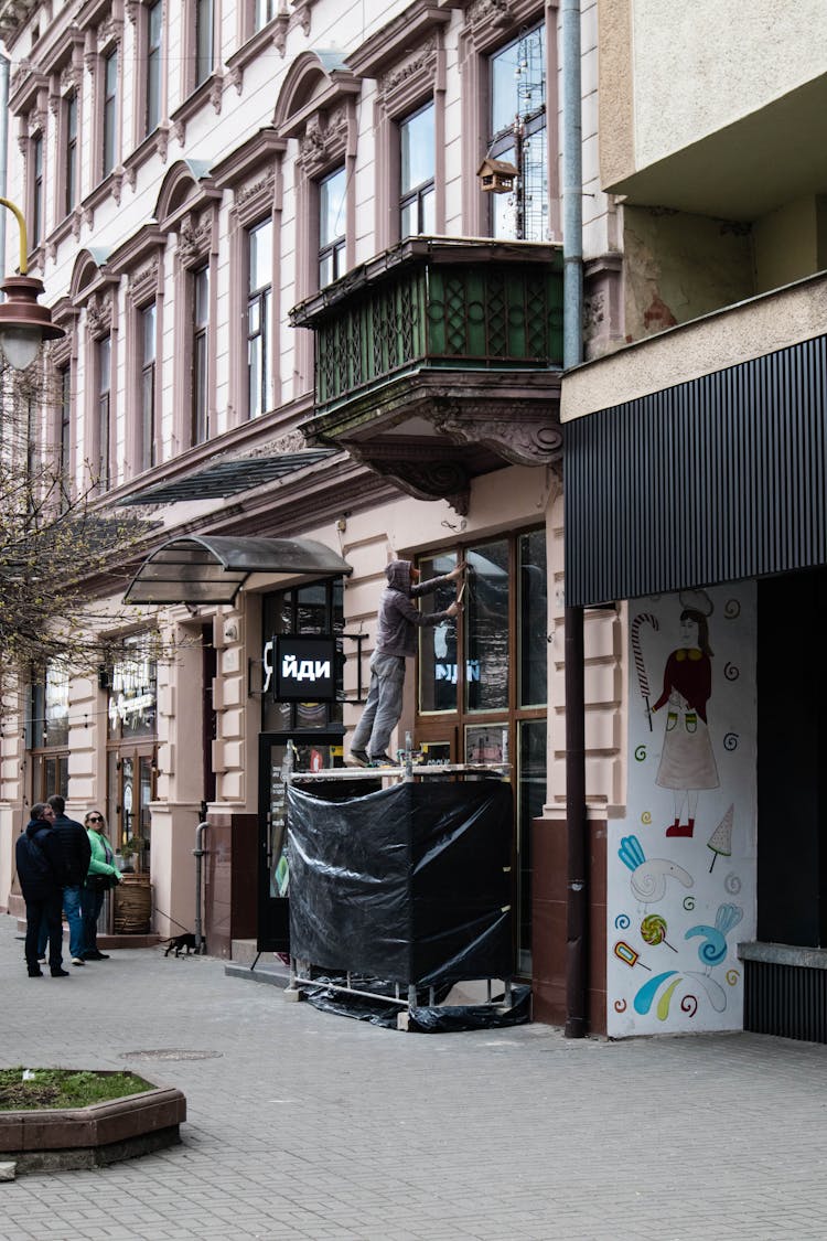 A Man Cleaning The Store Window