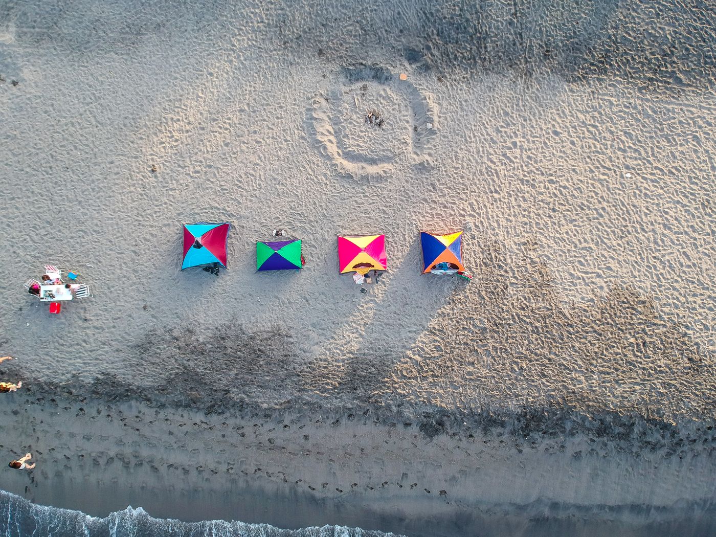 Beach tents arranged beside clear tropical water