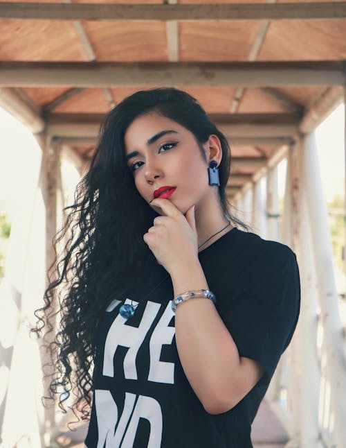 A Beautiful Woman Wearing a Black Shirt Holding Her Chin