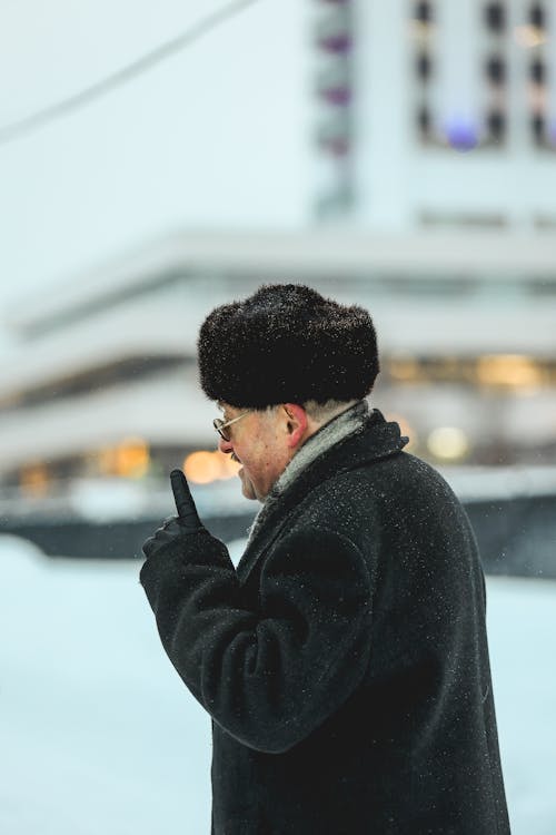 Elderly Man Wearing a Black Coat and Fur Hat