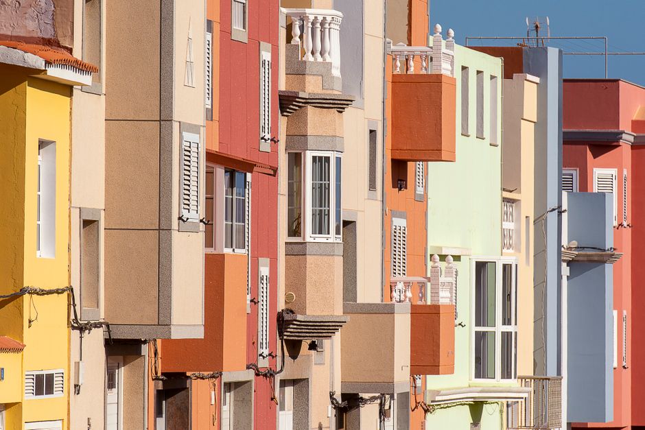 Una fila de casas adosadas vibrantes y coloridas que muestran arquitectura moderna en un entorno urbano.
