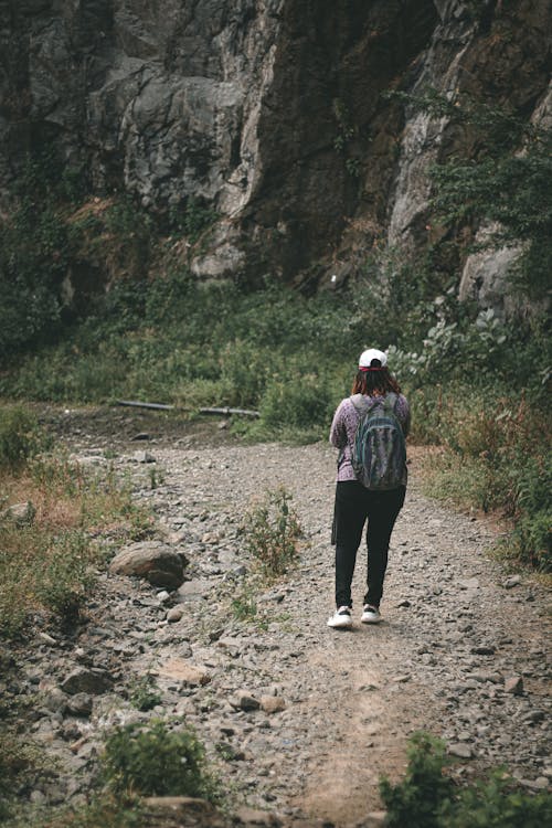 Back View of Woman Wearing Backpack and Cap Hiking 