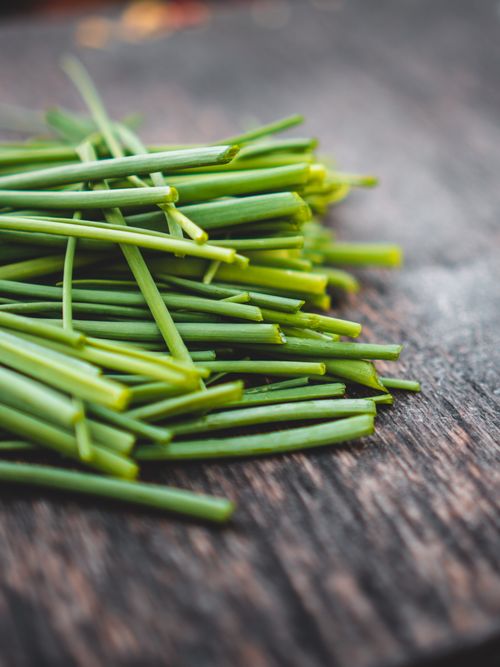 Free A close-up of freshly chopped green spring onions on a rustic wooden surface. Stock Photo
