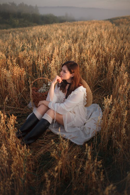 Woman in White Dress Sitting in Tall Grass 